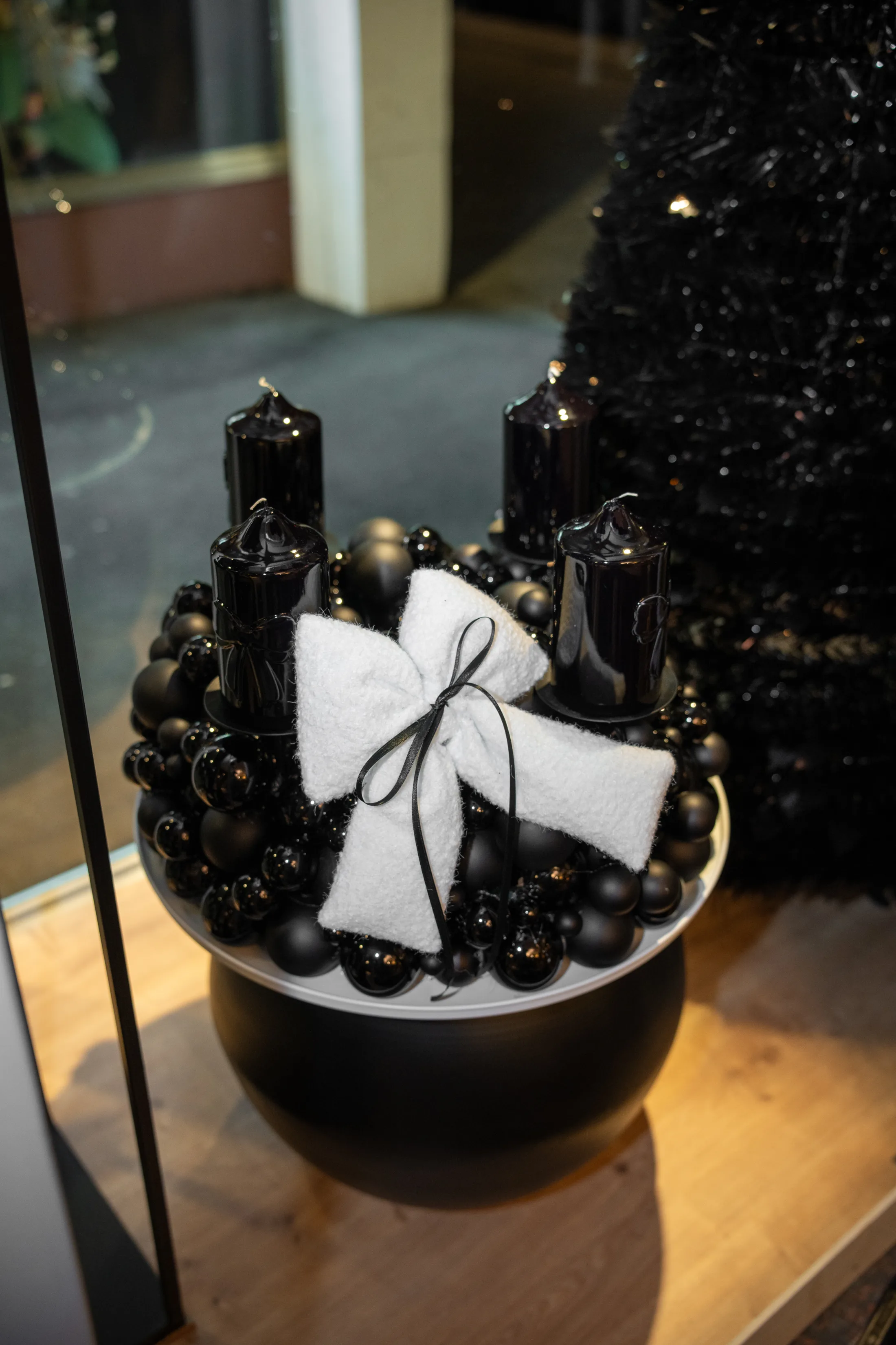 Adventskranz Schwarz auf einer schwarzen Kugelvase im Schaufenster von nummer eins