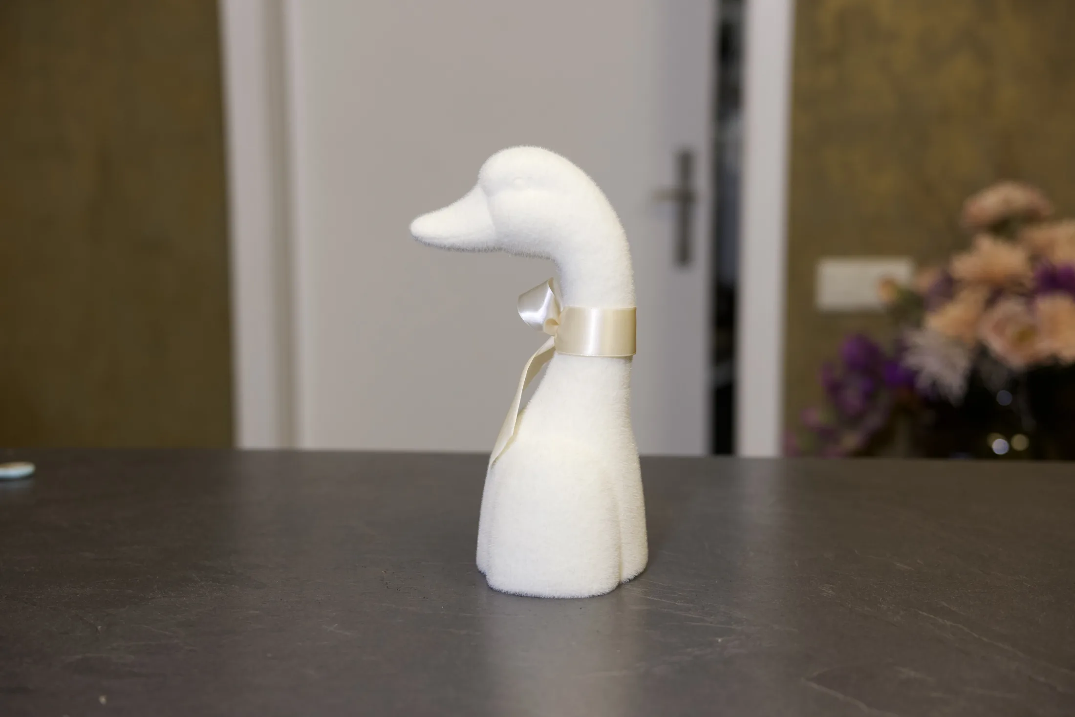 Gans in Creme von der Seite, mit Satinschleife am Hals